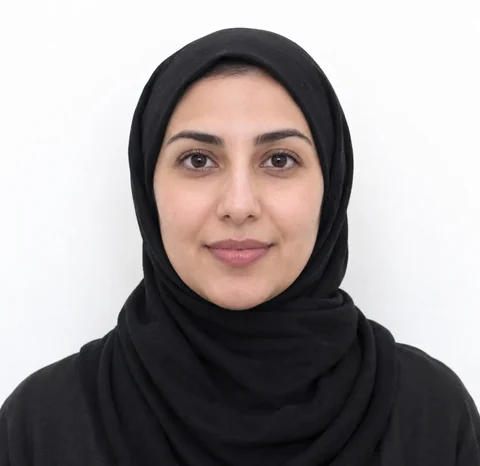 AI-generated photo of a woman wearing a plain black head covering that leaves her whole face visible, in front of a plain white wall